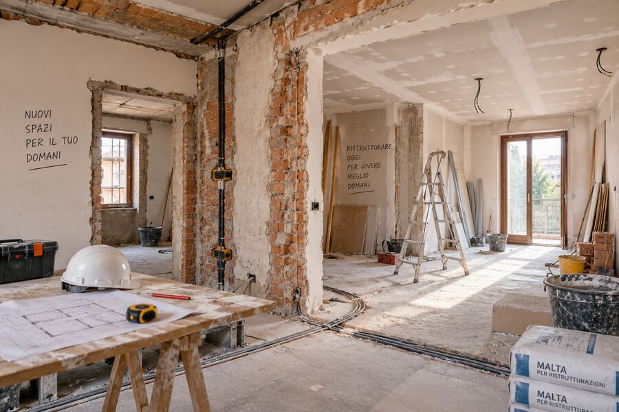 Cantiere di ristrutturazione interni a Roma: muri in mattoni a vista, impianti e attrezzi da cantiere